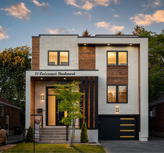 Modern two-story house with white and wooden exterior, black-framed windows, a front porch with steps, and a garage at dusk.