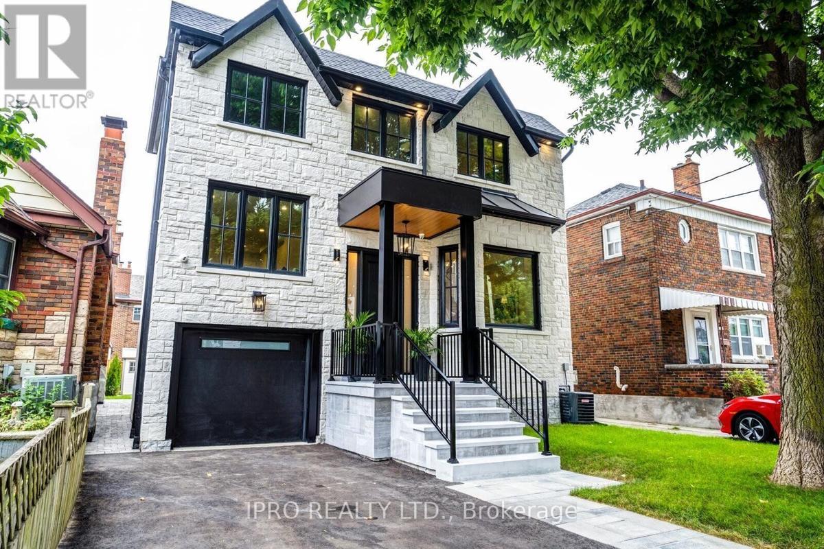 Modern two-story white brick house with black trim, a front porch, and a driveway garage.